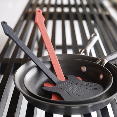 Two Flipper electric guitar spatulas, one red and one black, in frying pans