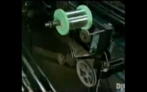 Close up of electric guitar string making machine in the D'Addario factory